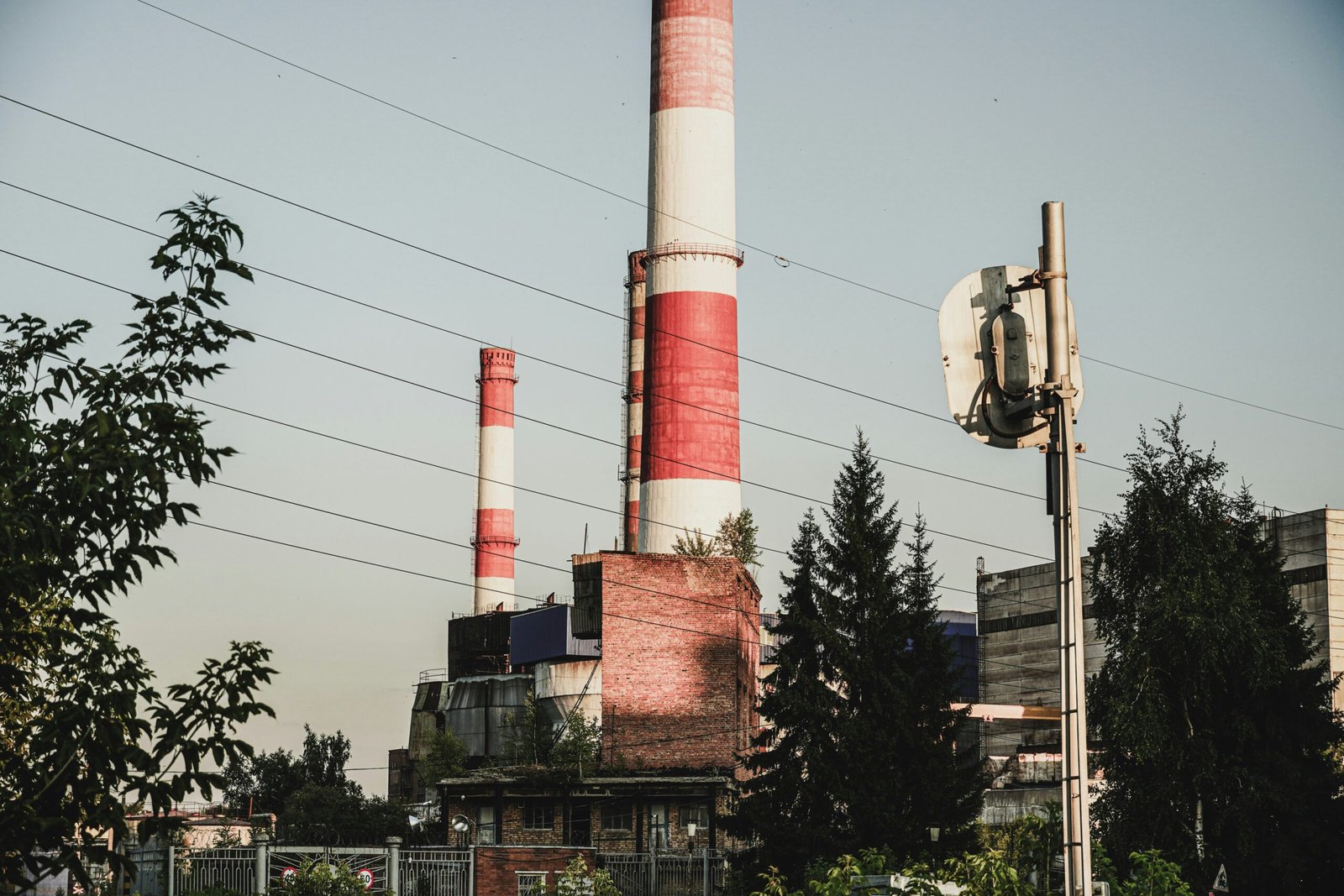 a red and white smokestack sitting next to a tall building